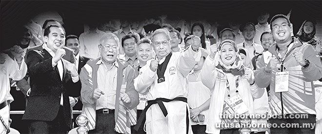 MINAT TAEKWONDO: Adenan memberi ‘pose’ istimewa bersama Menteri Belia, Sukan dan Solidariti Dato Sri Michael Manyin Jawong (dua kiri) dan Jamilah semasa merasmikan acara taekwondo pada temasya SUKMA Ke-18 di Stadium Tertutup, Petra Jaya.