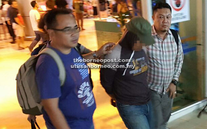 SIASATAN LANJUT: Pegawai imigresen yang ditahan di Kuantan, Pahang diiringi pegawai JSJ Sarawak tiba di Lapangan Terbang Antarabangsa Kuching untuk siasatan lanjut. 