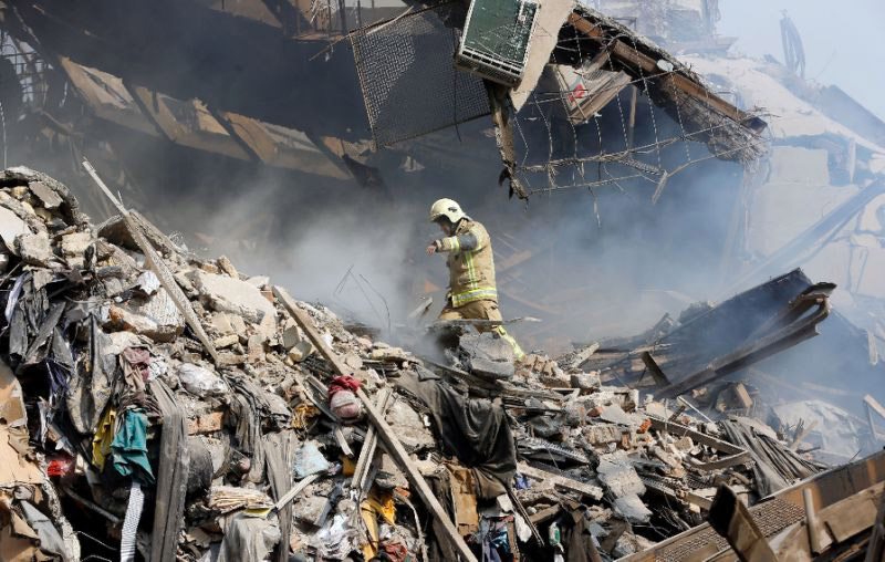 A firefighter walks through the debris of Iran's oldest high-rise, the 15-storey Plasco building in central Tehran, after it collapsed on January 19, 2017 following a fire .-AFP photo