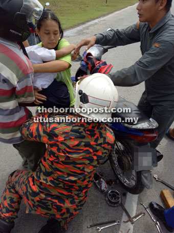 Rescuers help untangle the chain from the boy’s leg.
