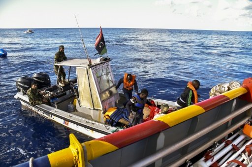 Libyan coastguards help migrants board a rescue ship run by Maltese NGO "Moas" and the Italian Red Cross, during a rescue operation, on November 4, 2016 -AFP photo