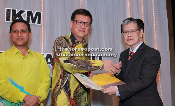 Chai (centre) receiving the FMIC award from MIC president Dato Dr Ong Eng Long during the Chemistry Night in Petaling Jaya recently. 