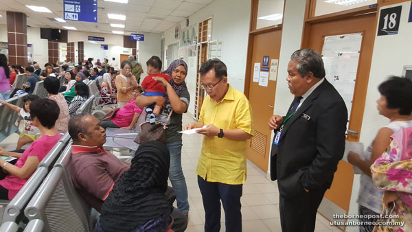 Dr Sim (second right) talks to one of the patients at the polyclinic. At right is Dr Nordin.