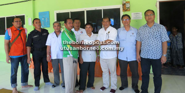 Ugak (right) hands over immediate cash assistance to one of the affected families. 