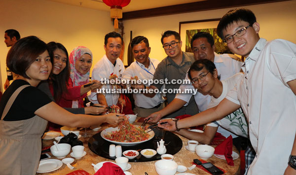 Khoo (fourth left) joins the hotel staff, media personnel and other invited guests in tossing Yee Sang.