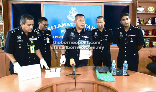 Azhar (centre) showing the confiscated Syabu.