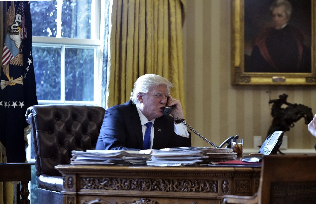 US President Donald Trump speaks on the phone with Russia's President Vladimir Putin from the Oval Office of the White House on Jan 28, 2017. AFP Photo