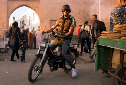 A Moroccan man drives his Peugeot 103 moped through a busy street in the capital Rabat. - AFP Photo