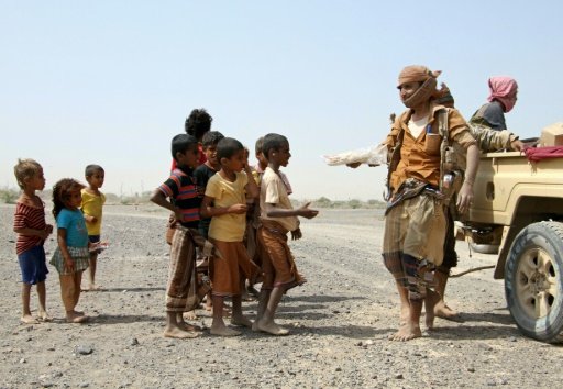 Pro-government fighters give food to Yemeni children on the road leading to the southwestern port city of Mokha -AFP photo