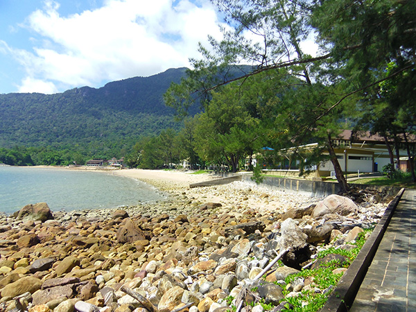 The swash and backwash of waves on a calm day at Damai Beach.