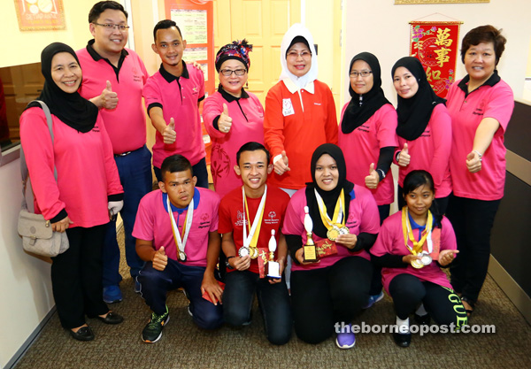 Fatimah (standing fourth right), Dayang Mariani (on her right) join others in giving the thumbs up to the Special Olympics state bowling team. Also seen are Kuching bowlers (front row, left to right) Wan Mohd Alizuan, Muhd Zul Adly, Nur Syawani and Asyikin Farhana. — Photo by Muhd Rais Sanusi