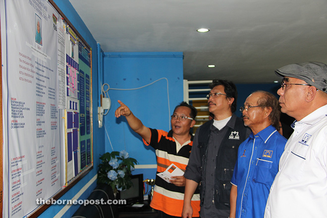 (From left) PBB Tanjong Datu Youth chief Jamsari Ahamad is seen giving a briefing to Dr Hazland, John and political secretary to the chief minister Buang Bolhassan at the operations room in Lundu.