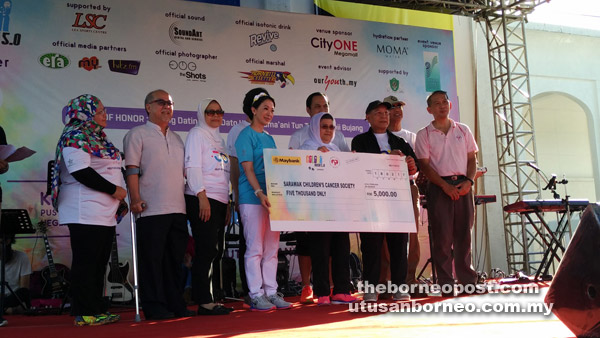 Juma’ani (fifth left) presents the mock cheque to Lorna (fourth left) while Liew (second left) and Hamid (second right) look on. 