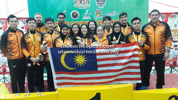 The Malaysia team with manager Nik Razeen Daud (right) and coaches Ong Beng Hee (left), Mika Monto (third right) after the prize presentation at the Sarawak Squash Centre in Petra Jaya yesterday.