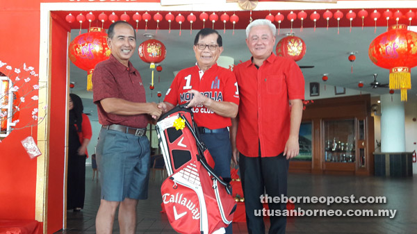 Aziz (left) receiving his prize from ex-deputy chief minister Datuk Patinggi Tan Sri Dr George Chan while KGS captain Dr David Sylvester Ling looks on at KGS Clubhouse yesterday.