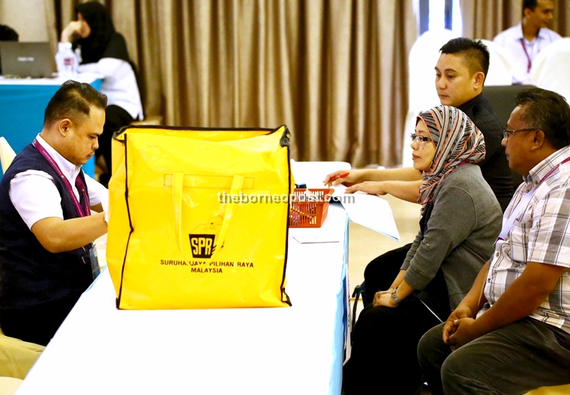 EC officers with a ballot box at Dewan Masyarakat Lundu. 