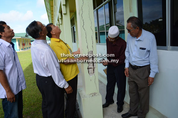 Ting (third left) inspects one of the building’s pillars that has cracks on it – a large chip on the side exposes the steel rods inside the pillar.  