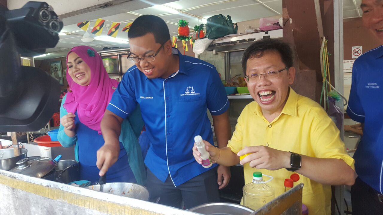 Sim (right) and Azizul (centre) seen trying their hands to cook Mi Jawa at a Malay stall in one of the coffee shops in Lundu town. 