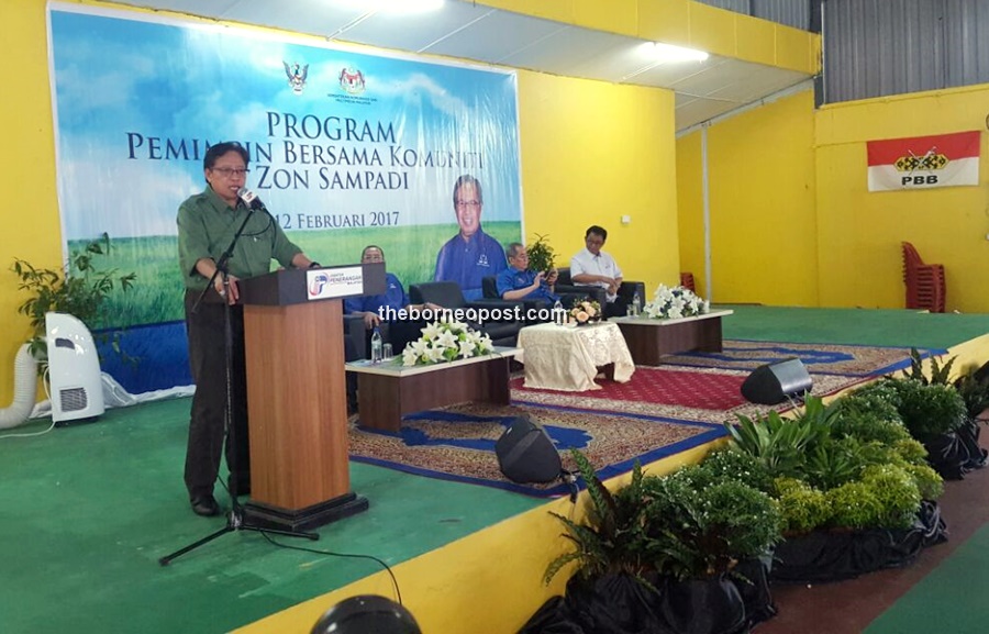 Abang Johari (left) seen giving his speech at Kampung Sampadi, Lundu today.