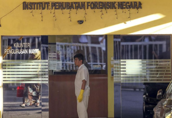 A medical staff member stands at the entrance of the forensic department at a hospital in Kuala Lumpur, Malaysia, Thursday, Feb 16, 2017. AP Photo