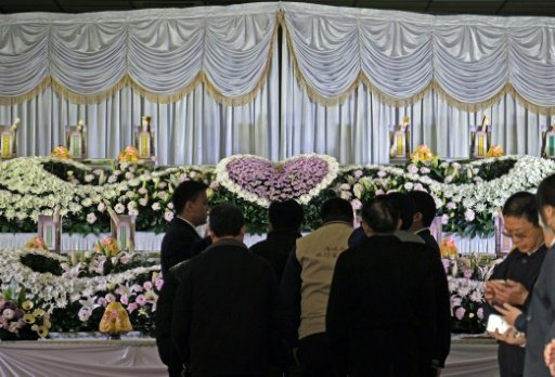 Relatives (C) mourn the victims of a bus crash in Taiwan that killed 33 local tourists. - AFP Photo