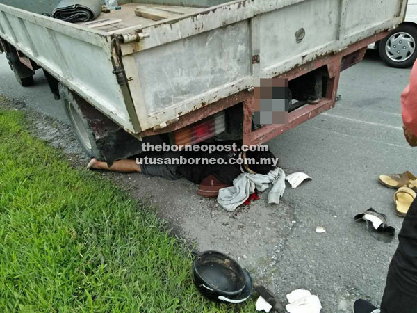 The injured motorcyclist lies beneath the lorry following the crash.