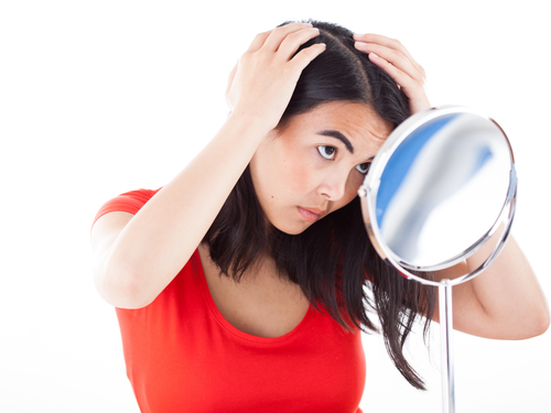 A woman looks in the mirror for grey hairs. (File photo, 12.05.2016 in Hamburg. Please credit: "Christin Klose / dpa".)