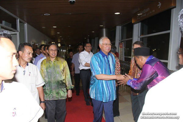 Najib (right) and Hishammuddin (behind Najib) being greeted by community leaders upon their arrival. Also with them is Abang Johari (third left). — Photo by Chimon Upon