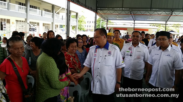 Ismail (third right) shakes hands with the public upon his arrival at the function. Also seen at right is Azizul.