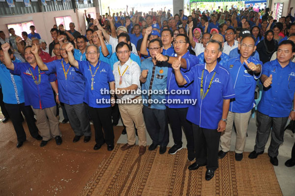 Uggah (fourth left) and Dr Rundi on his left and others raise their hands to show support for BN.