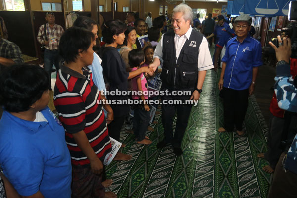 Awang Tengah being welcomed by the villagers of Kpg Pueh upon his arrival yesterday. 