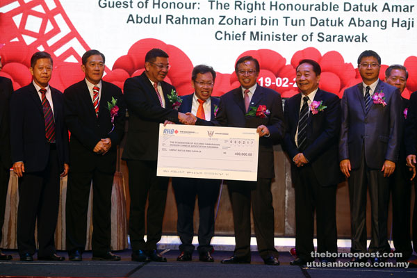 Abang Johari (third right) presents the cheque to Wee (third left) while Wong (second right), Dr Sim (fourth left), Fu (right) and others look on. — Photo by Muhammad Rais Sanusi