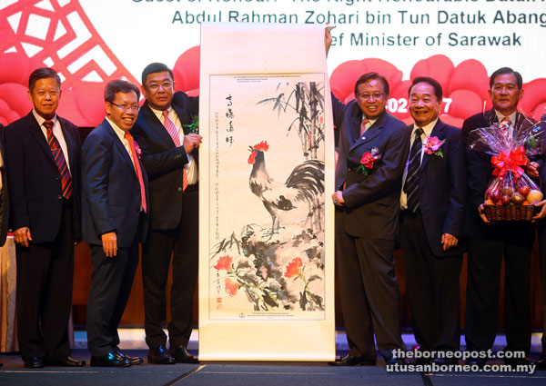 Wee (third left) presenting a Chinese calligraphy painting to Abang Johari (third right) as a token of appreciation while Wong (second right), Dr Sim (second left) and others look on. — Photo by Muhammad Rais Sanusi