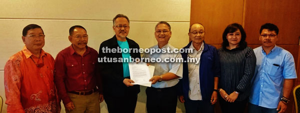 Kallang (fourth right) handing over the draft copy of the pre-proposal for a community initiated land and environmental conservation initiative in Ulu Baram to Sapuan in the presence of (from left) James Nyuran from the Kenyah community in Baram, Komeok, Paul Chai, who is the ITTO project leader for Sarawak, Zarina Shabli, who is the officer for the Conservation of Forest and Siah representing the Penan community from Baram.