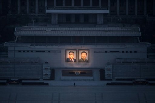 A pedestrian passes portraits of late North Korean leaders Kim Il-Sung (L) and Kim Jong-Il in Pyongyang, seen from the landmark Juche tower on Feb 17, 2017. AFP Photo