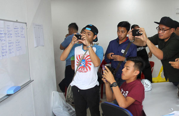 Participants seen snapping away at the match schedule of Utusan Borneo Cup Futsal Tournament after the draw.