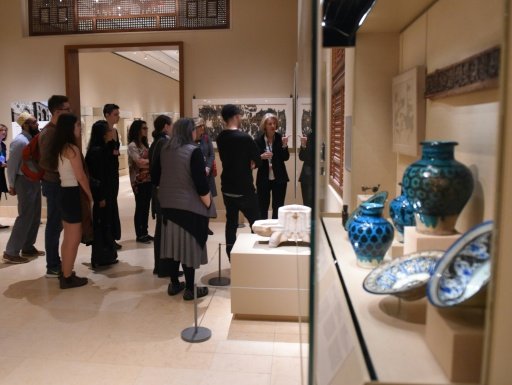 Curators at the Metropolitan Museum of Art talk to visitors about works created in the lands that are now Iraq, Syria, Iran and Yemen, four of the seven countries affected by the recent travel ban - AFP/Jenny Matthew