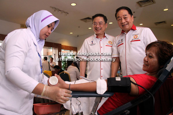 Wong (right) and Lo watching a medical staff attending to a blood donor.