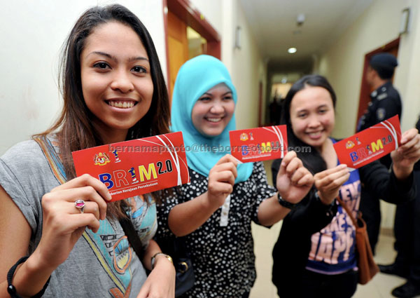 GOVT CARES: BR1M recipients (from left) Zalia Abdul, 23, Nur Aida Darnizul, 22, and Miranti Nadasiki Munawari, 25, holding up the BR1M cash aid after the presentation ceremony and Chinese New Year celebration for Segambut parliamentary constituency at DBKL community hall. — Bernama photo