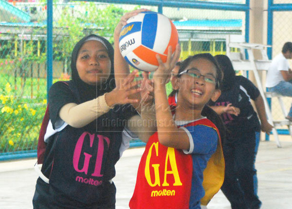 COMPETITIVE SPIRIT: SJK Chung Hua No.1 Goal Attacker (GA) Florence Wong (right) fights for the ball with SK St Mary player in their Group C league match of the Kuching Zone A Inter-School Netball Championship at SMK Tabuan Jaya yesterday.