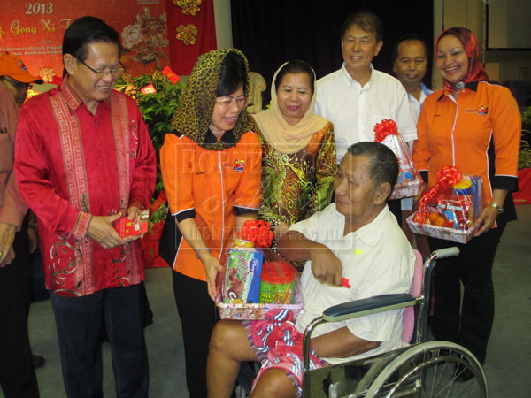 FOR YOU : Fatimah (second left) presents a hamper to one of the recipients at the Bouquet of Love event, witnessed by (from left) Lee, Rosey, Sebastian and Noriah.