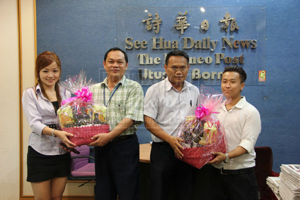 KUCHING: Crown Square Management marketing executives Yuki (left) and Bryan Ting (right) presenting Chinese New Year (CNY) hampers to The Borneo Post chief reporter Churchill Edward (second left) and Utusan Borneo chief reporter Saibi Gi. The handover yesterday was held at The Borneo Post office at Crown Towers in Kuching.  — Photo by Anasathia Jenis
