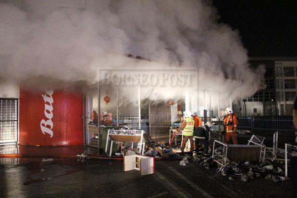 MIDNIGHT FIRE: Firemen trying to locate the source of the fire through the thick smoke after gaining entry into the building.