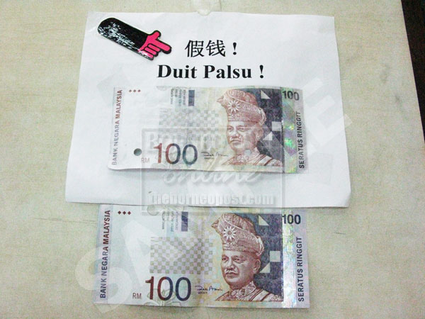 LOOKS REAL: The fake note (top) received by a Shell petrol station before Chinese New Year. Compare it with the real note below.