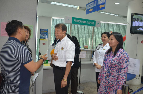 STEP-BY-STEP: Ting (third left) listens attentively to an applicant pouring his grouses over the delay in passport processing.