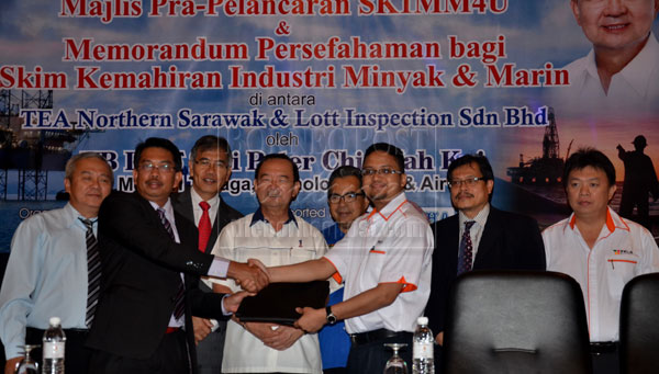 SIGNED AND DELIVERED: Hafizul (third right) exchanges the MoU document with Masri while (from third left) Ose, Chin, Ajmad Lai and others look on. 