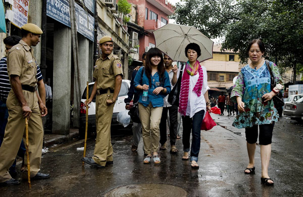 SECURITY PRECAUTION: In this photograph taken on Sept 19, 2010, foreign tourists walk past Indian policemen towards Jama Masjid mosque after foreign tourists were attacked by unknown gunmen near the mosque in New Delhi. — AFP photo