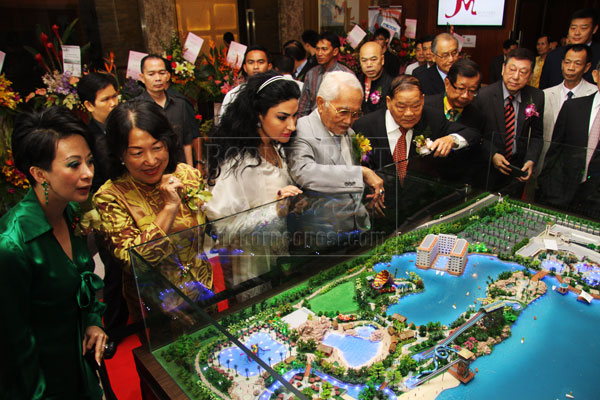 TOWARDS A VIBRANT CITY: Taib (fourth left), flanked on his right by wife Puan Sri Ragad Kurdi Taib and Datuk Professor Lau Siu Wai (chairman of Miri Housing Group of Companies) on his left, checking out the model of the proposed water theme park in Desa Senadin at the opening of Meritz Hotel.