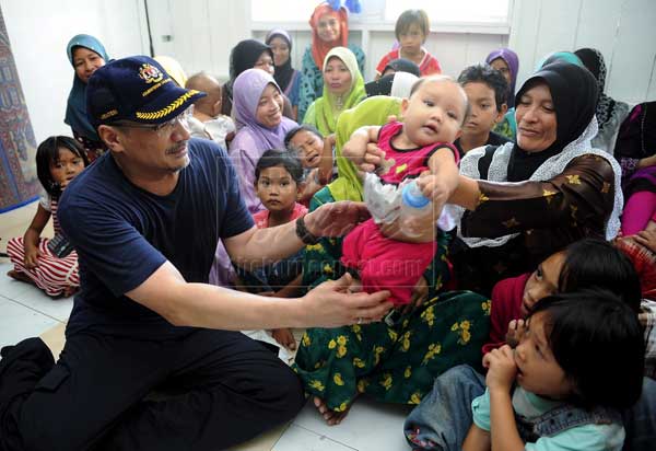 MESRA: Hishammuddin beramah mesra dengan adik Siti Asrah Duasan berusia tiga bulan ketika beliau melawat Kampung Senallang Lama di Semporna, semalam. — Gambar Bernama