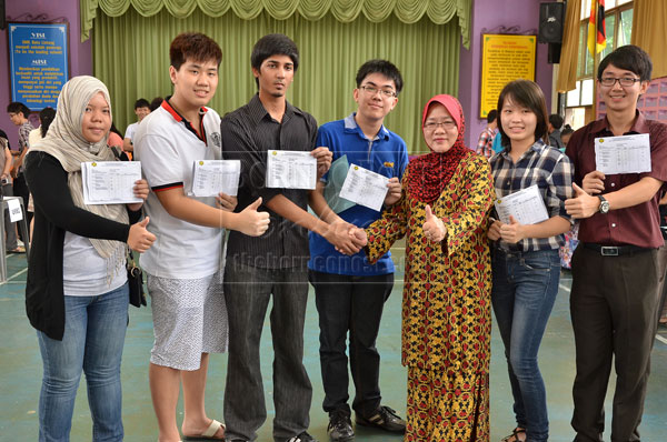 TOP GUNS: Principal Saftuyah (third right) with the two top scorers Chan (fourth right) and Davis (third left) as well as the other high achievers. — Photo by Hii Kheng Juong